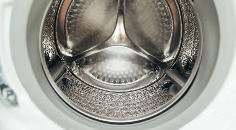 Detailed view of a clean, modern washing machine drum, showcasing shiny stainless steel interior